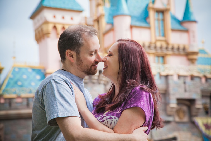 Couple posing in front of Sleeping Beauty Castle