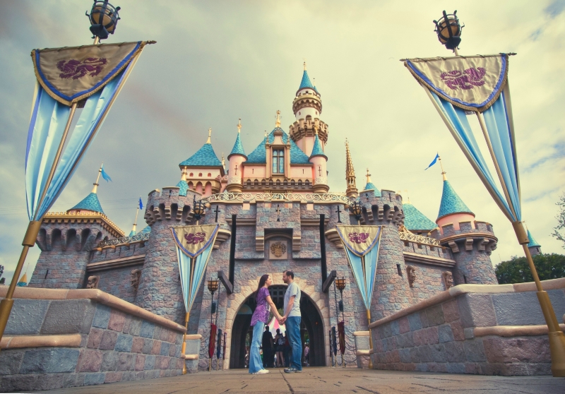 Couple posing in front of Sleeping Beauty Castle at Disneyland