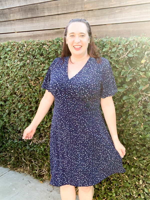 Woman wearing blue polka dot dress and twirling