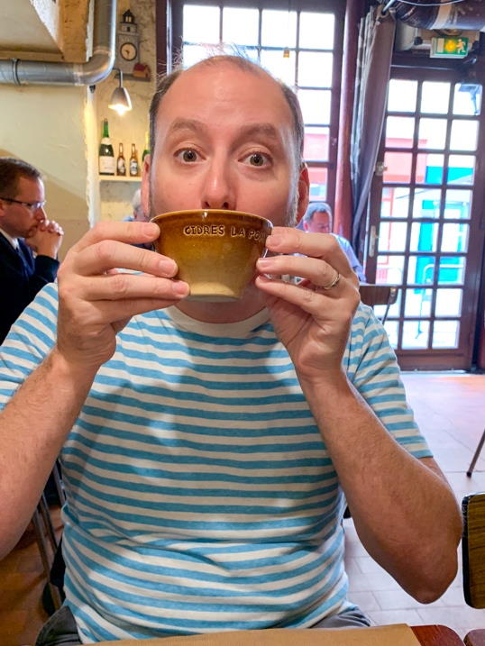 Man drinking cider from bowl