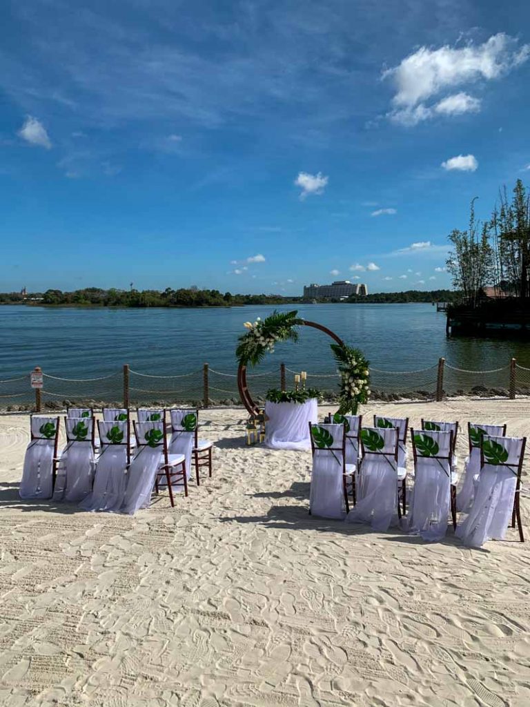 Wedding ceremony set up with white chairs at luau beach at disney's polynesian resort