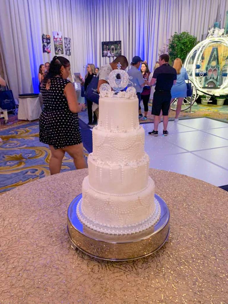 White 4 tiered wedding cake with Cinderella carriage cake topper