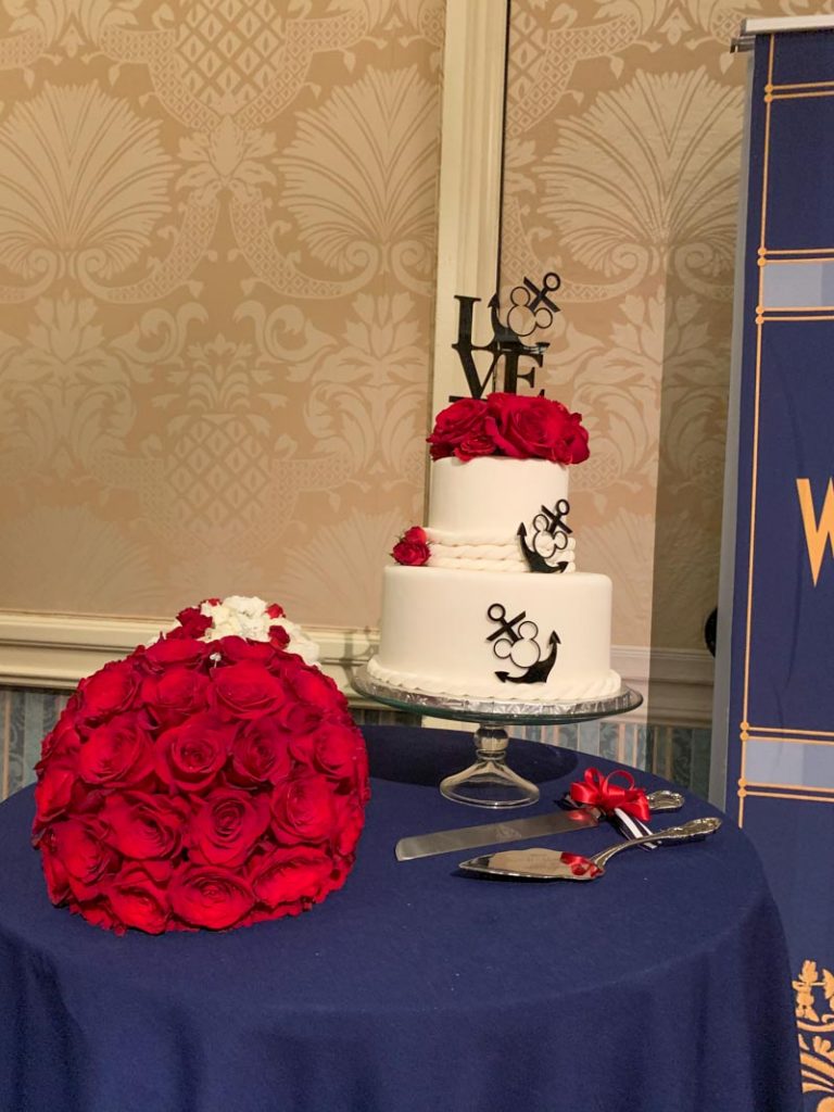 two tier cake with red roses on top, and red roses bouquet