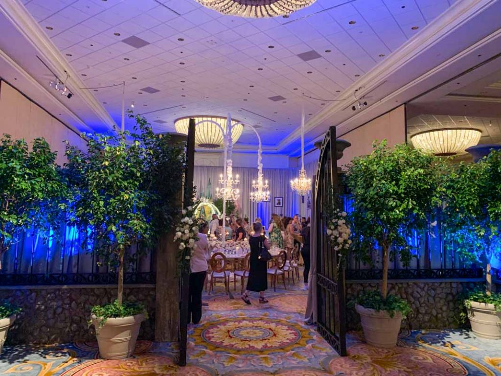 wedding reception ballroom entrance with faux trees and iron gates