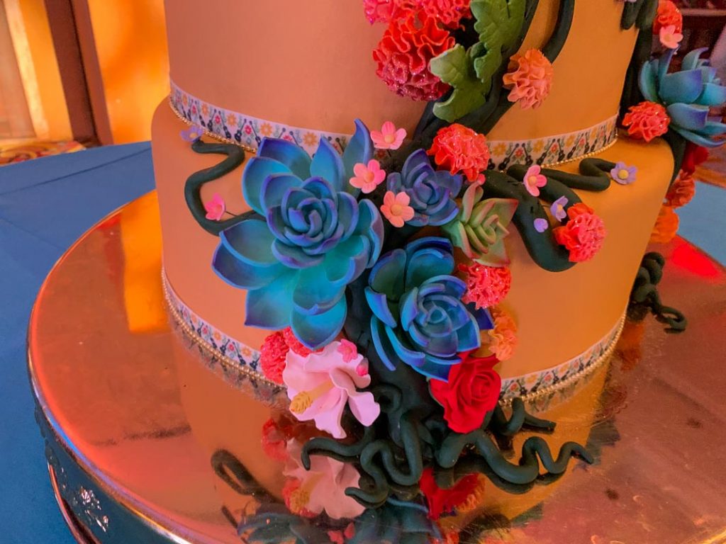 Close up of blue and pink roses made of icing on a wedding cake