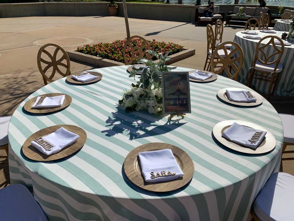 close up of wedding reception table with green striped tablecloth