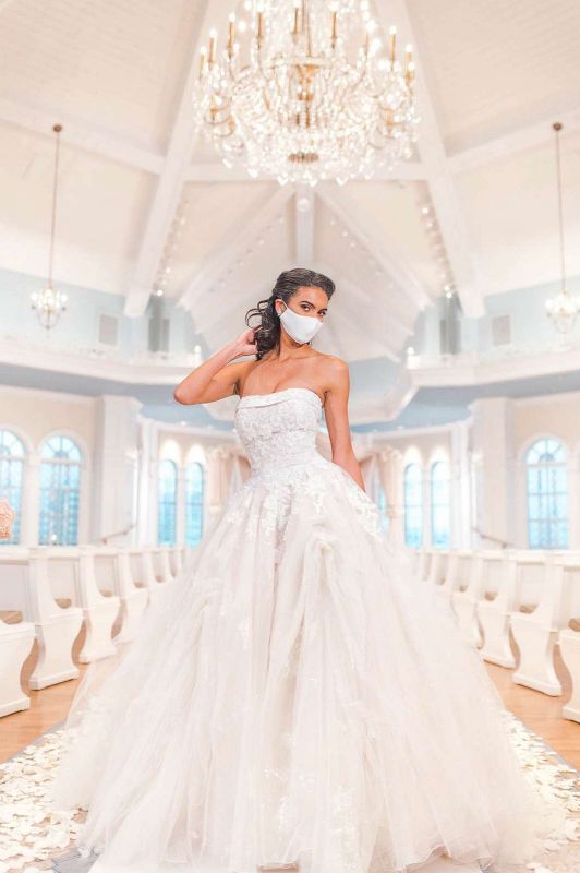 Woman wearing wedding gown and white face mask