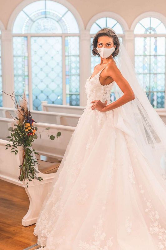 Woman wearing wedding gown and white face mask