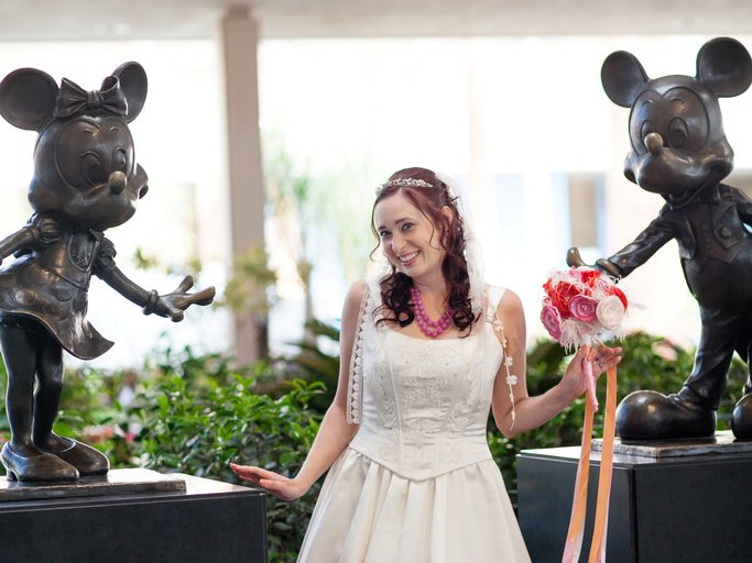 Bride with Mickey Mouse and Minnie Mouse statues at The Disneyland Hotel