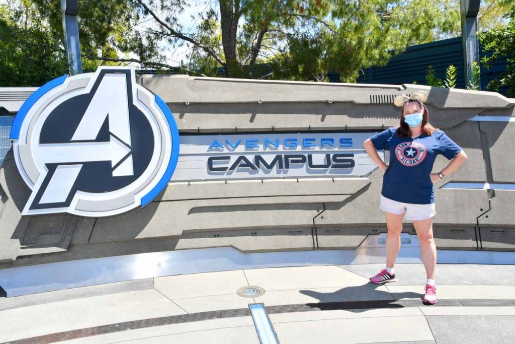 Woman standing in front of sign that reads "Avengers Campus"