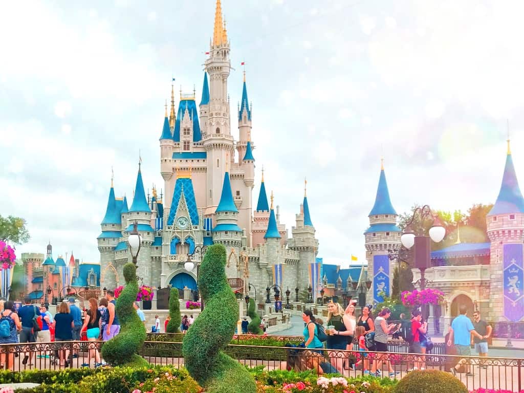 Cinderella Castle at Magic Kingdom at Walt Disney World in Orlando Florida. The castle is a pale pink with light blue roofing and turrets.