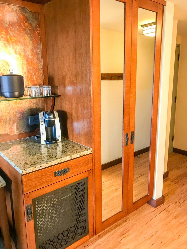 Mirrored double closet doors next to shelf with coffee maker inside Disney's Grand Californian Hotel room