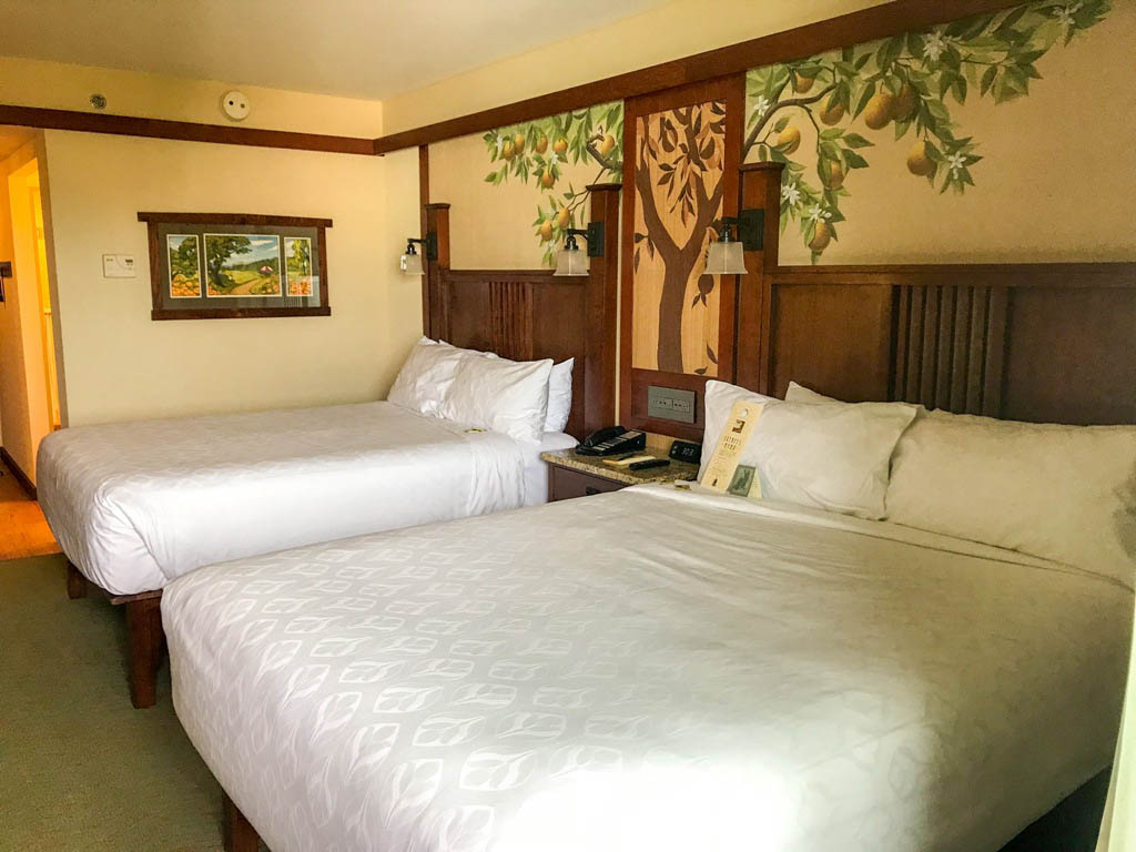 Two queen beds with tree mural on the wall behind the beds at Disney's Grand Californian Hotel room