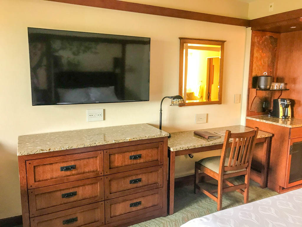 Dresser drawers, desk, and wall mount flat screen TV inside Disney's Grand Californian Hotel room