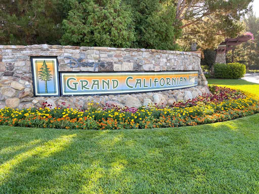 Outdoor stone sign with colorful tile that reads "Grand Californian Hotel"