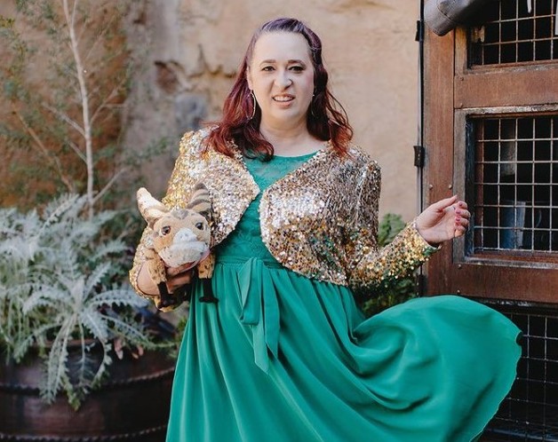 Woman wearing green dress with gold sequin bolero jacket