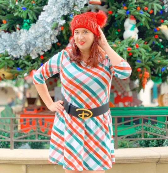 Woman wearing white dress with red and green crisscross design