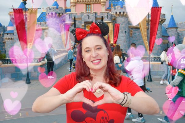 Woman wears Minnie Ears in front of Disneyland castle