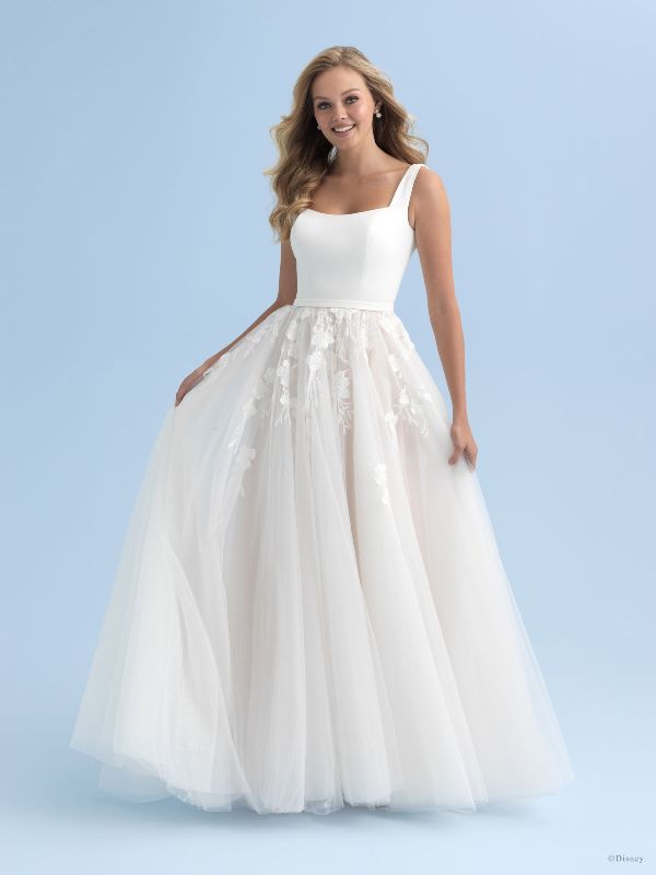 Woman wears white ballgown in front of blue background