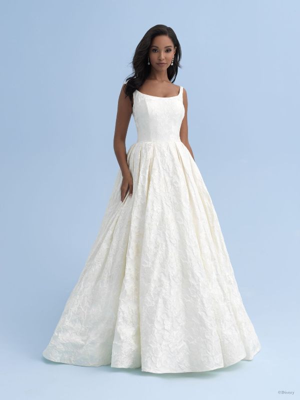 Woman wears a line wedding dress in front of blue background