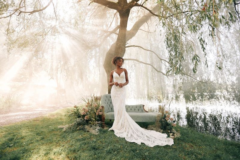 Bride wearing form fitting wedding gown in a forest