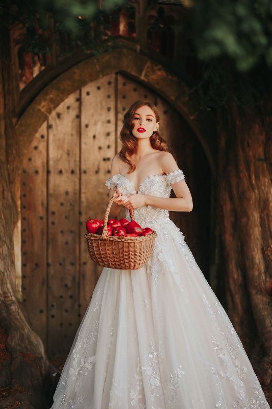 Bride wears wedding dress inspired by Snow White while holding basket of red apples