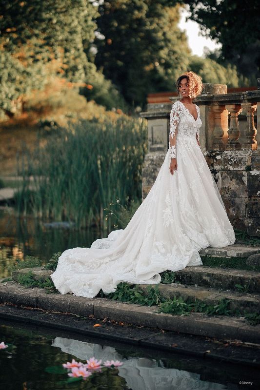 Woman wears bridal gown with lace sleeves and long train