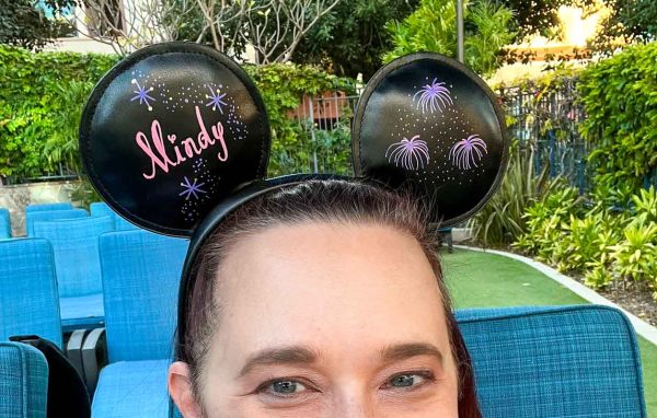 Women takes selfie while wearing personalized black Mickey Mouse ears