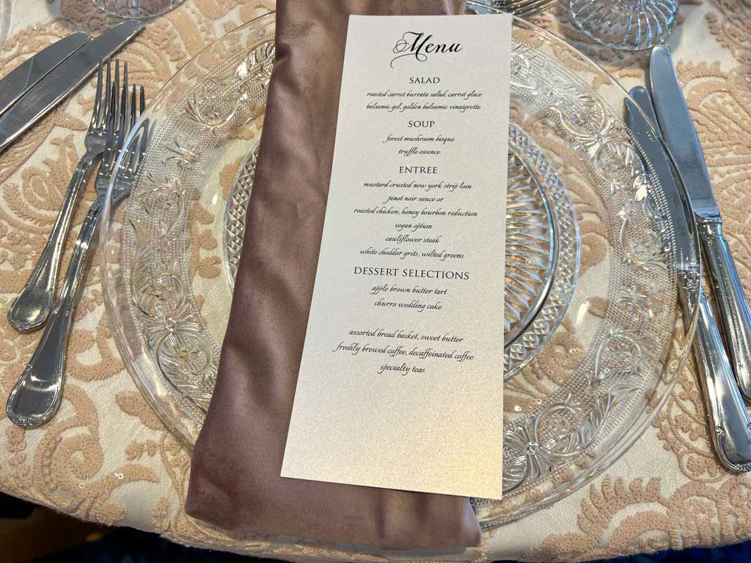 Close up of white food menu on top of purple napkin