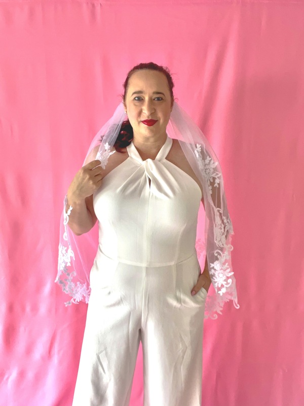 Woman in white jumpsuit and bridal veil