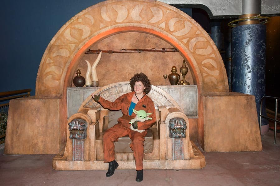 Woman in Peli Motto costume sitting on Boba Fett's throne