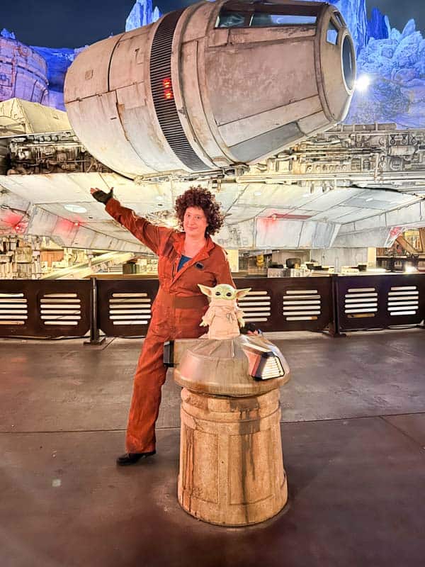 Woman in Peli Motto costume standing in front of Millennium Falcon