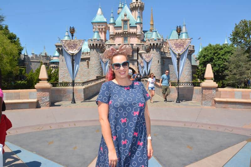 Woman stands in front of Sleeping Beauty Castle at Disneyland California