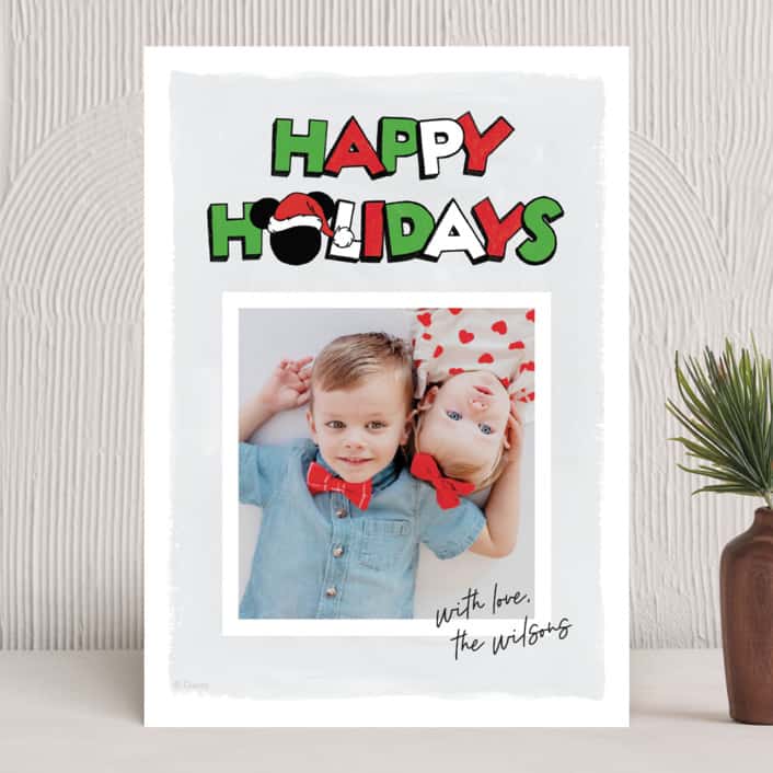 Holiday card featuring photo of two kids with text "Happy Holidays" in playful Disney font