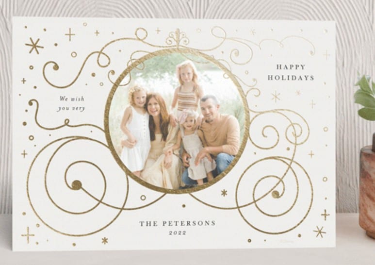 Holiday card with gold outline of Cinderella carriage, with family photo in the center