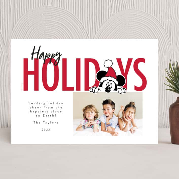 White holiday card with text "happy holidays" at the top and Mickey Mouse wearing a santa hat