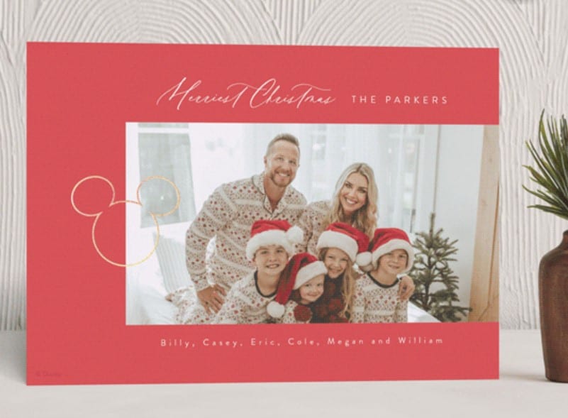 Red holiday card with family photo in the center.