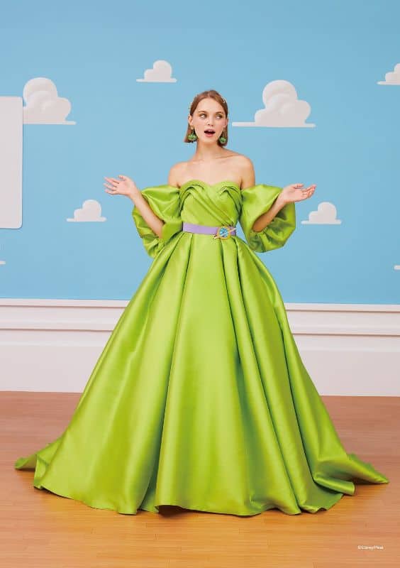 Woman wears light green ballgown with puffy sleeves