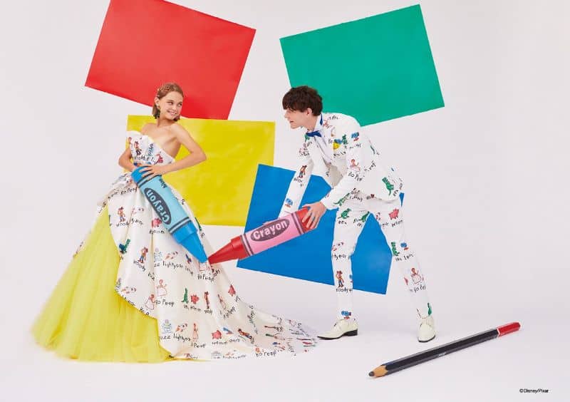 Woman and man wear ballgown and suit with drawings of Toy Story characters on the clothing