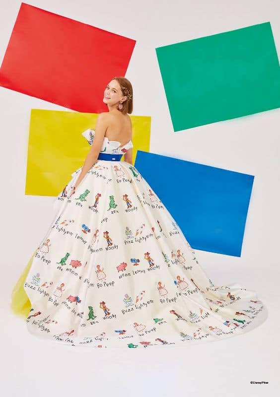 Woman wears ballgown with drawings of Toy Story characters on the dress