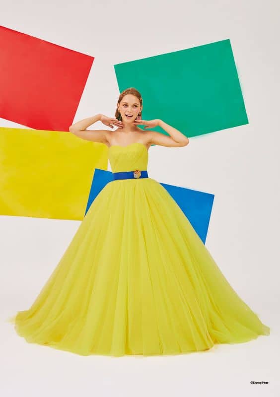 Woman wears light green ballgown with blue sash