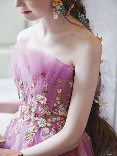 Close up of woman wearing Rapunzel inspired ballgown, showing flower detail on corset