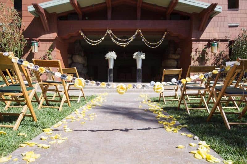 Wedding Garden at Disney's Grand Californian decorated for a ceremony, with wood chairs and yellow roses