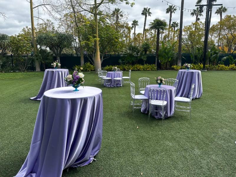 A pre-reception set up at the Disneyland Hotel with purple tablecloths and white chairs