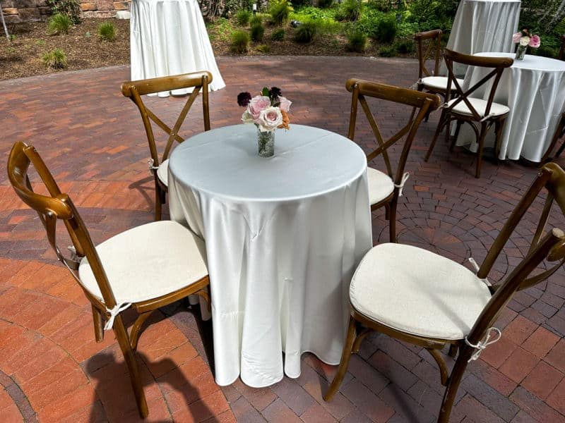 Cocktail table with white linen and dark wood chairs at Brisa Courtyard