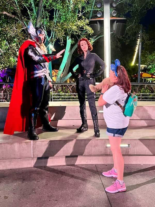 Woman holds up CHOCO bear while meeting Thor and Black Widow at Avengers Campus