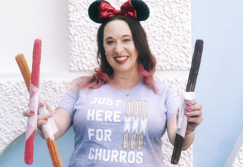 a woman holding three specialty churros at Disneyland Park