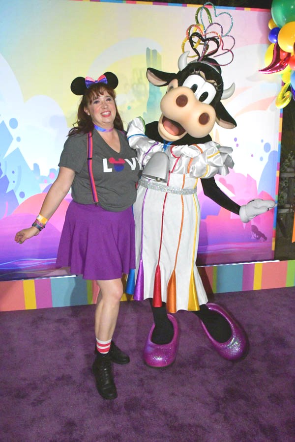 Woman poses with Clarabelle at Disneyland Pride Nite