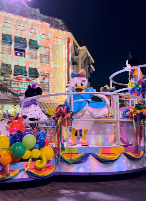 Daisy waving from a parade float during Disneyland Pride Nite