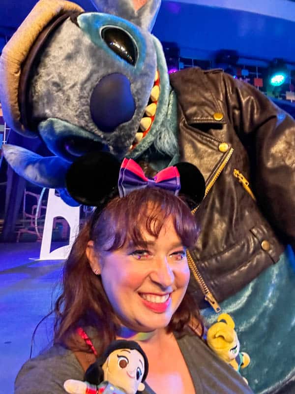 Woman poses with Stitch on Disneyland Pride Nite